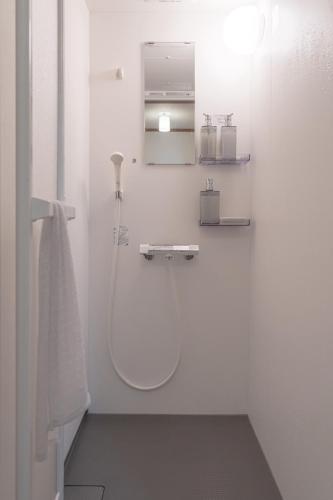 a white bathroom with a shower and a sink at ALLEY HOUSE-nachikatsuura in Nachikatsuura