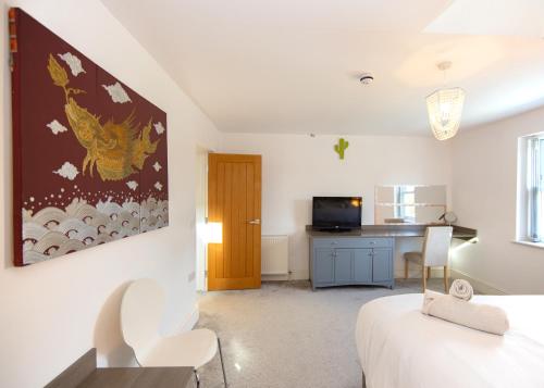 a room with a bed and a desk and a kitchen at Transvaal House Ely in Ely