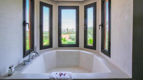 a large bath tub in a bathroom with windows at Dreamcation Villa in Marrakesh