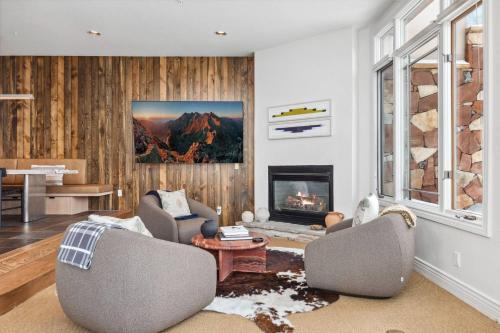 a living room with two chairs and a fireplace at Pine Meadows 135 ~ Pine Meadows 135 in Telluride