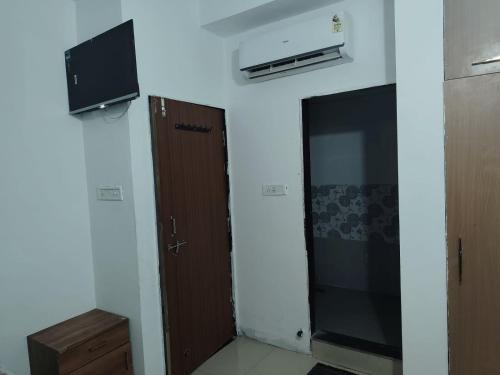 a room with a door and a television on the wall at Naik Homestay in Indore