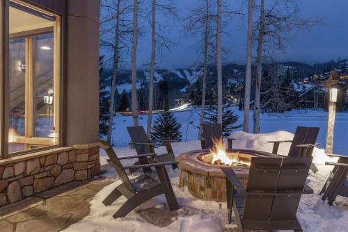 a patio with chairs and a fire pit in the snow at Benchmark Dr 101 in Telluride