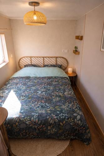 a bedroom with a bed with a blue comforter at Mobil-home rénové tout confort, terrasse couverte, climatisation, arrivée autonome in Fourmies