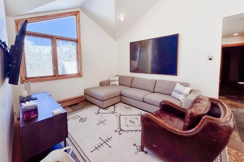 a living room with a couch and a tv at Benchmark Dr 101 ~ Guest House in Telluride