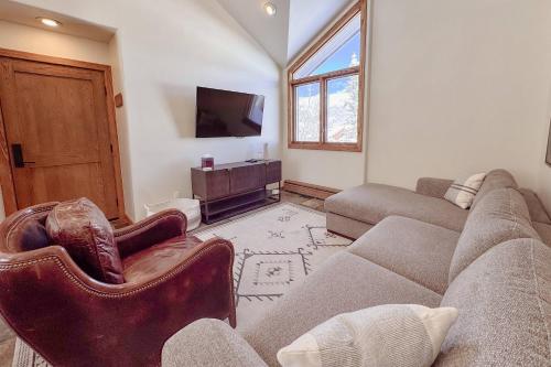 a living room with a couch and a tv at Benchmark Dr 101 ~ Guest House in Telluride