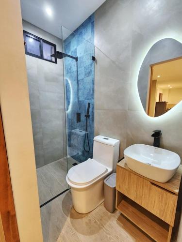 a bathroom with a toilet and a sink and a shower at Islander Suite in Puerto Baquerizo Moreno