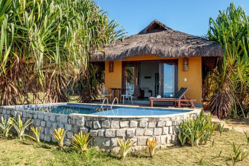 a small house with a swimming pool in front of it at Pousada Spa dos Amores in São Miguel do Gostoso