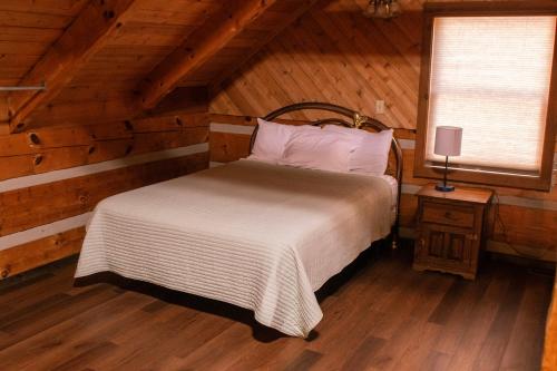 a bedroom with a bed in a wooden cabin at Mountain Hideaway in Sevierville