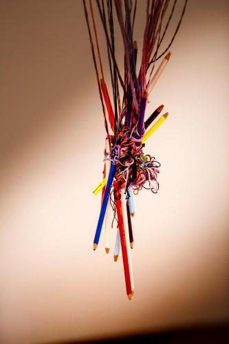 a bunch of colored pencils hanging on a stick at La Casa del Poeta Enna - Pergusa in Enna