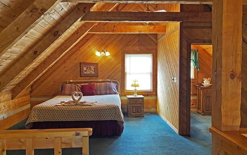 a bedroom in a log cabin with a bed and a window at Trails End- Your Romantic Getaway Awaits! in Sevierville