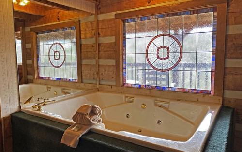a bath tub in a room with stained glass windows at Trails End- Your Romantic Getaway Awaits! in Sevierville