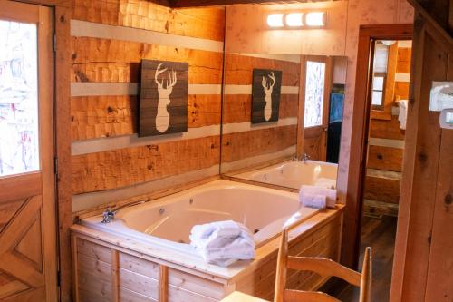 a tub in a room with a wooden wall at Copeland Creek- Tiny Cabin in Sevierville