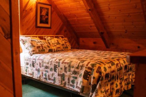 a bed in a room in a log cabin at Copeland Creek- Tiny Cabin in Sevierville