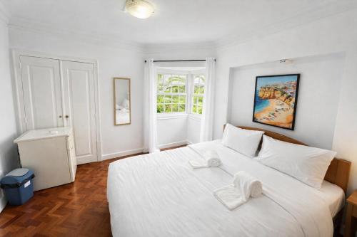 a bedroom with a white bed with two towels on it at Relax Guesthouse & Hostel Lagos Central in Lagos