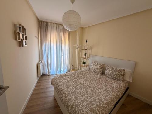 a bedroom with a bed and a large window at Apartamento Cueto II in Soto del Barco