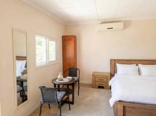 a bedroom with a bed and a table and chairs at Olive tiny house in Tuval