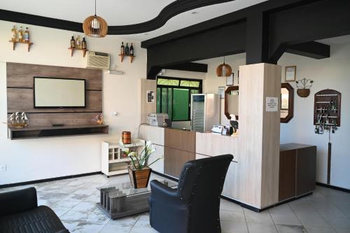 a lobby with a bar with a tv on the wall at Hotel Minas Brasil in Salinas