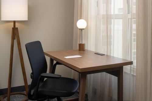 a wooden table with a chair and a lamp at Residence Inn by Marriot Clearwater Downtown in Clearwater