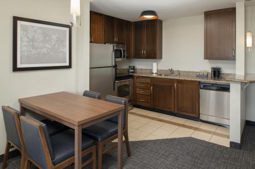 a kitchen with a wooden table and a dining room at Residence Inn by Marriot Clearwater Downtown in Clearwater