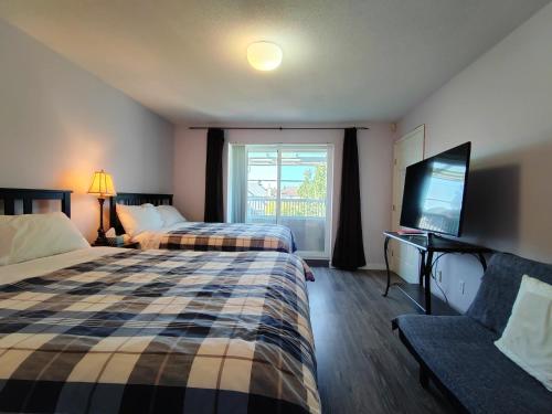 a hotel room with two beds and a flat screen tv at Bed Plus House close YVR Airport in Richmond