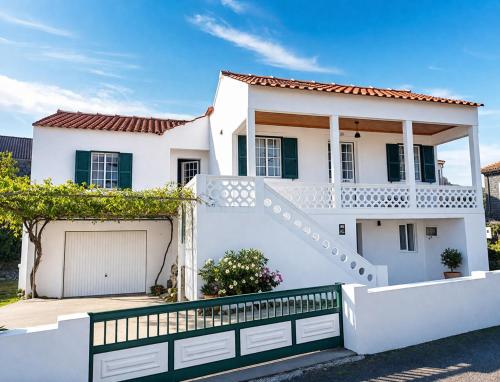 a white house with a fence in front of it at Inn Fraga in Ribeirinha
