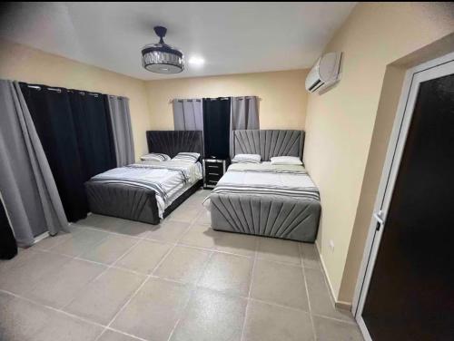 a room with two beds in a room with curtains at Villa Barias in Baní