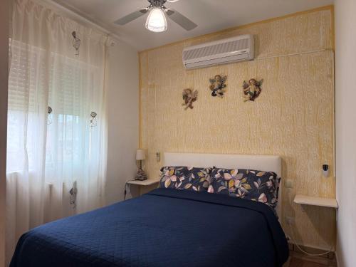 a bedroom with a blue bed and a fan at Relajante Casa Atalaya in Cardiel de los Montes