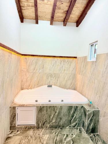 a bath tub in a room with a stone wall at Los Azufres Spa Natural in Los Azufres