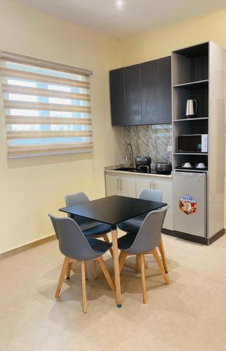 a kitchen with a table and chairs in a kitchen at KIFA Stays in Laniya