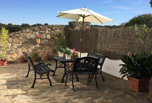 a table and chairs with an umbrella on a patio at El Aleznal in Trujillo