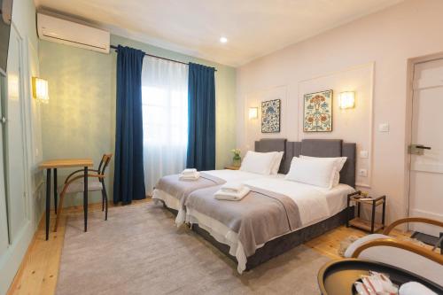 a bedroom with a bed and a table and a window at Mihail Residence - Old Town of Kavala in Kavála