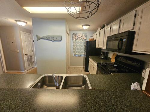 a kitchen with a sink and a microwave at Teal Lake 212 in North Myrtle Beach