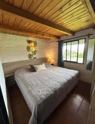a bedroom with a large bed with a wooden ceiling at Atahualpa Yupanqui 2 in Tafí del Valle
