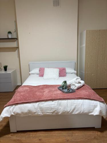 a white bed with a tray of towels on it at Comfort at Sunderlands in Forest Hill
