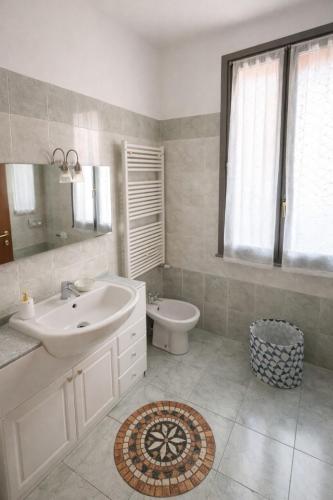 a white bathroom with a sink and a toilet at La Corte Guesthouse appartamento indipendente con giardino privato in Cornate dʼAdda