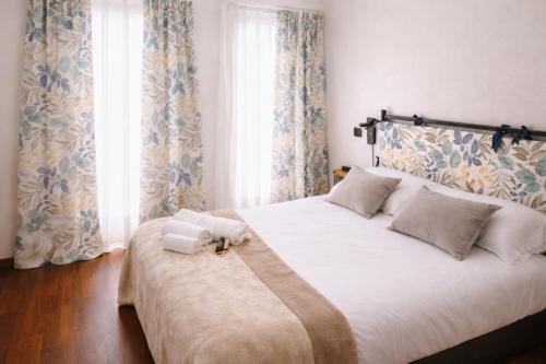 a bedroom with a large bed with towels on it at La Corte Guesthouse appartamento indipendente con giardino privato in Cornate dʼAdda