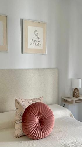 a bed with a large pink pillow on it at Estudio TAU in Jerez de los Caballeros