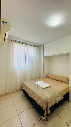 a bedroom with a large bed with a window at Apto completo térreo 2quartos - praia e shopping in Rio das Ostras