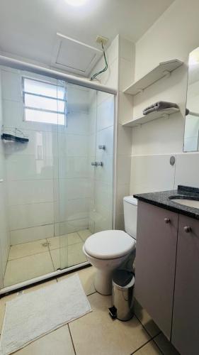 a bathroom with a toilet and a glass shower at Apto completo térreo 2quartos - praia e shopping in Rio das Ostras