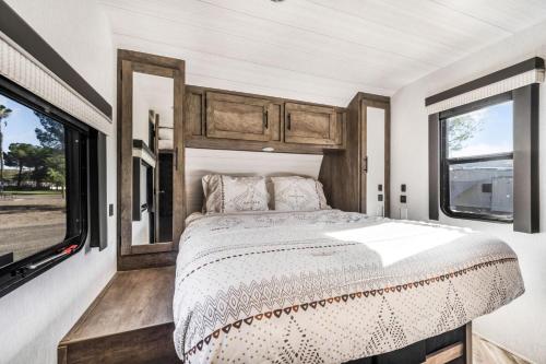 a bedroom in an rv with a bed and windows at De Anza Springs Resort in Titus
