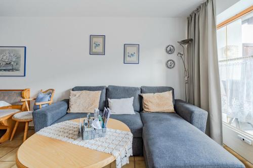 a living room with a blue couch and a table at Fewo Barth in Bad Hindelang