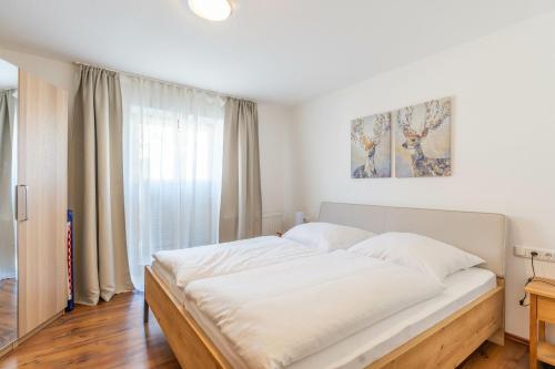 a bedroom with a large white bed in front of a window at Bergluft in Bad Hindelang
