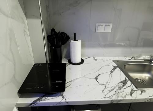 a bathroom counter with a sink and a counter top with a laptop at Blue Sea Nest in Paralia Katerinis