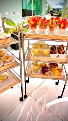 a buffet with plates of food and bowls of fruit at Pousada Villa Monale in Barreirinhas