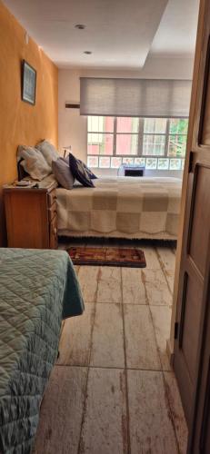 a bedroom with two beds and a window at Tu Lugar en Capilla Del Monte in Capilla del Monte