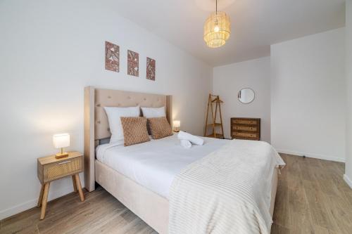 a bedroom with a large white bed and a lamp at 2 Bedroom Apartment for 6 with Private Parking - Elevator - High-Speed WiFi in Champigny-sur-Marne