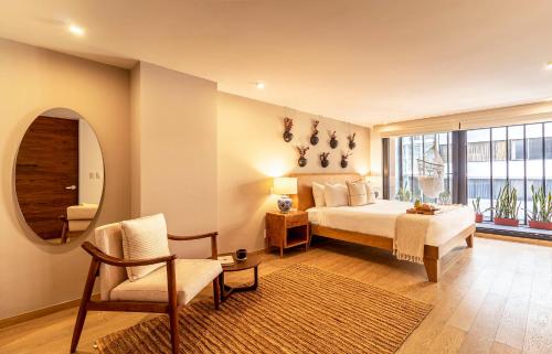 a bedroom with a bed and a chair and a mirror at Horacio by Kukun in Mexico City