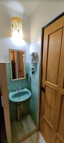 a bathroom with a sink and a mirror and a door at Casa Andy a 5 min del aeropuerto de Veracruz in Veracruz