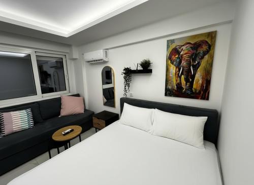a small bedroom with a bed and a couch at Blue Sea Nest in Paralia Katerinis