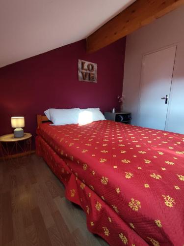 a bedroom with a large bed with a red bedspread at Le Doux Refuge in Ustou
